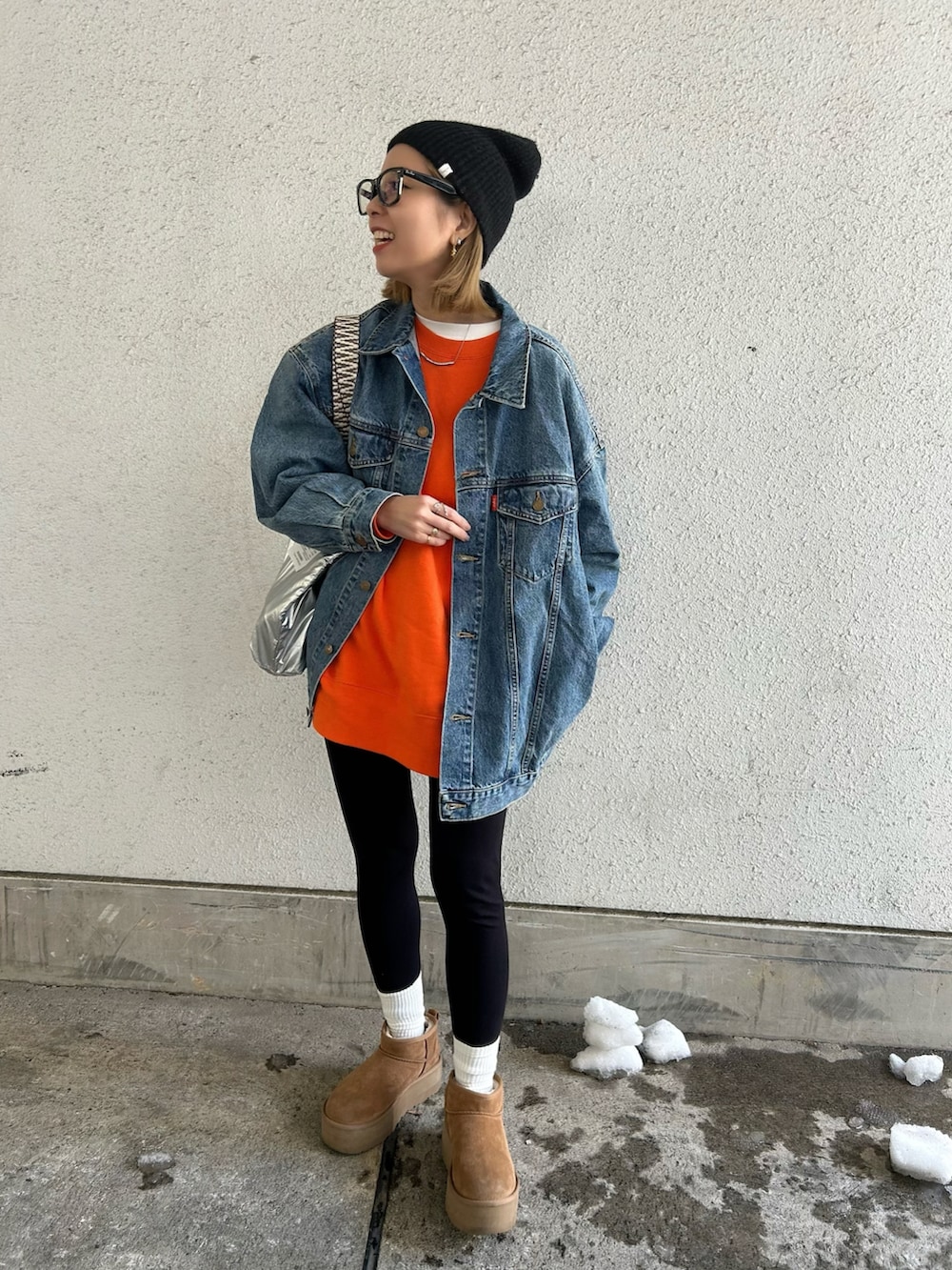 ブルー系のデニムジャケット、オレンジ系のスウェット、ブラウン系のブーツを着用したレディースの冬コーディネートの3枚目の写真