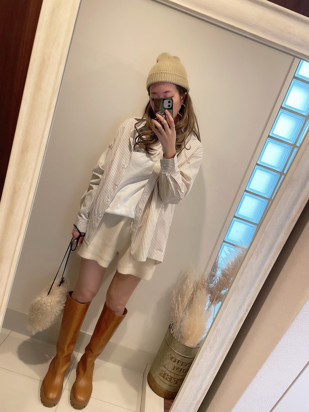 ベージュ系のシャツ/ブラウス、ホワイト系のショルダーバッグ、ブラウン系のブーツを着用したレディースの冬コーディネートの4枚目の写真