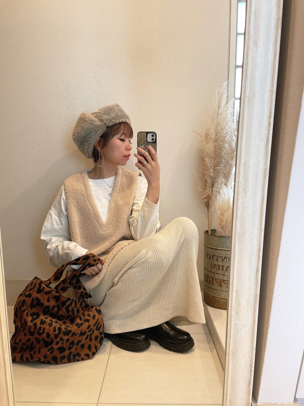 ホワイト系のベスト、ベージュ系のスカート、ベージュ系の帽子を着用したレディースの冬コーディネートの3枚目の写真