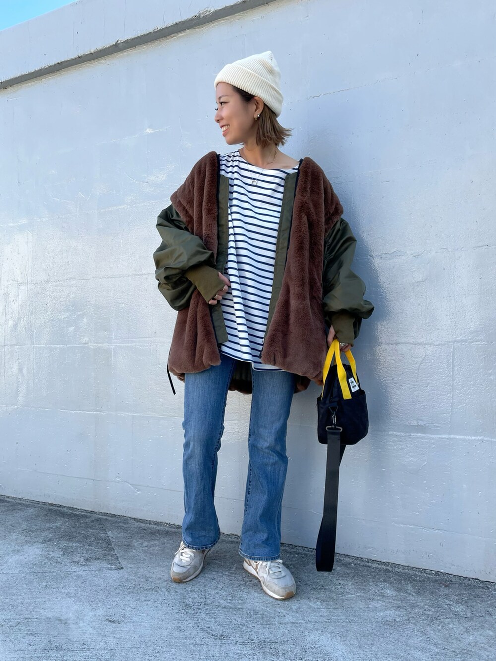 グリーン系のMA-1、ブラック系のトートバッグ、ベージュ系のスニーカーを着用したレディースの秋コーディネートの3枚目の写真