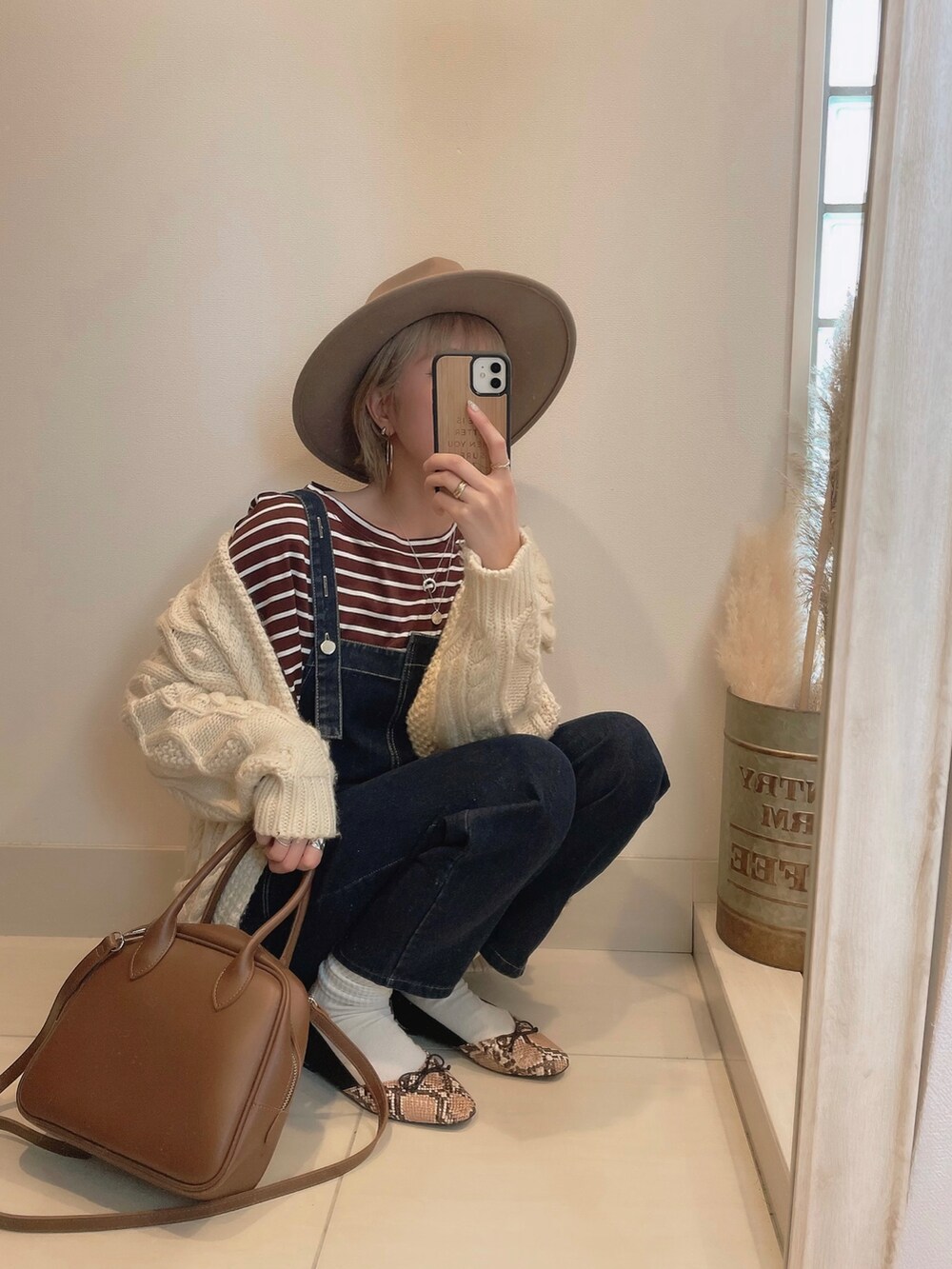 ホワイト系のカーディガン/ボレロ、ブラウン系のショルダーバッグ、ブラウン系のハットを着用したレディースの冬コーディネートの2枚目の写真