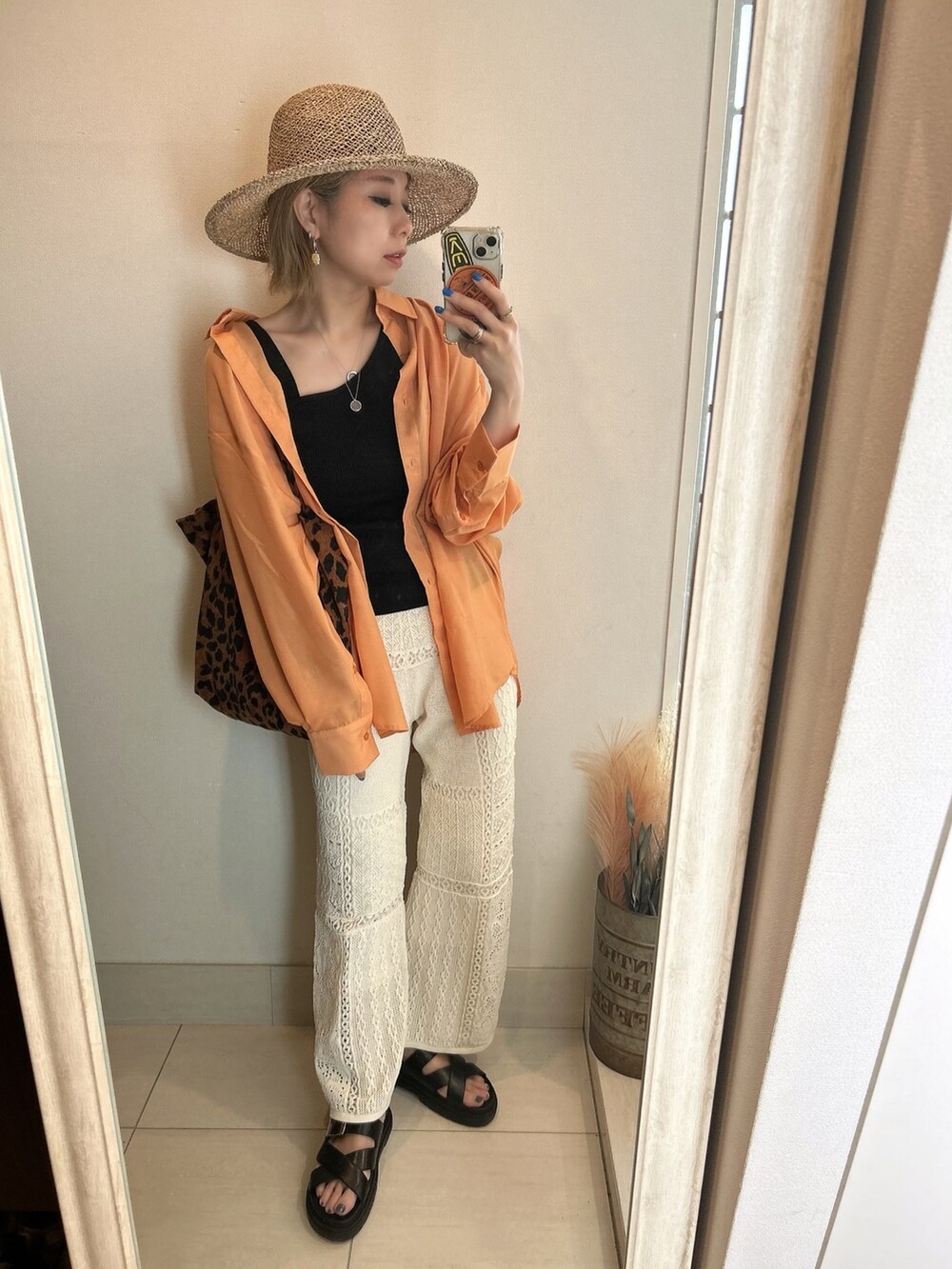 オレンジ系のシャツ/ブラウス、ブラック系のサンダル、ブラック系のTシャツ/カットソーを着用したレディースの夏コーディネートの2枚目の写真