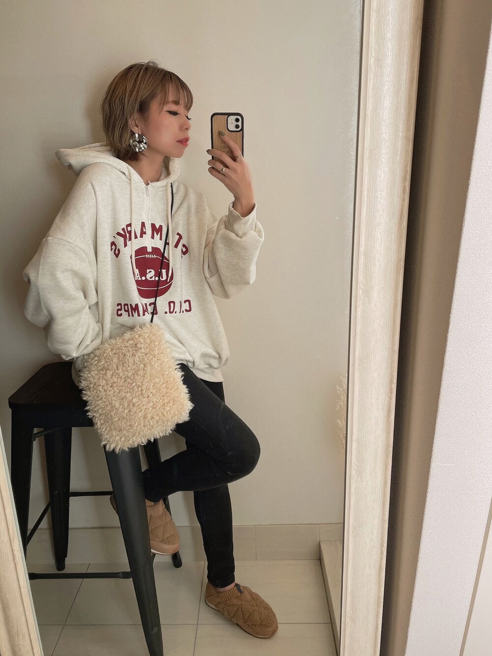 グリーン系のモッズコート、ホワイト系のショルダーバッグ、ベージュ系のスリッポンを着用したレディースの秋コーディネートの3枚目の写真