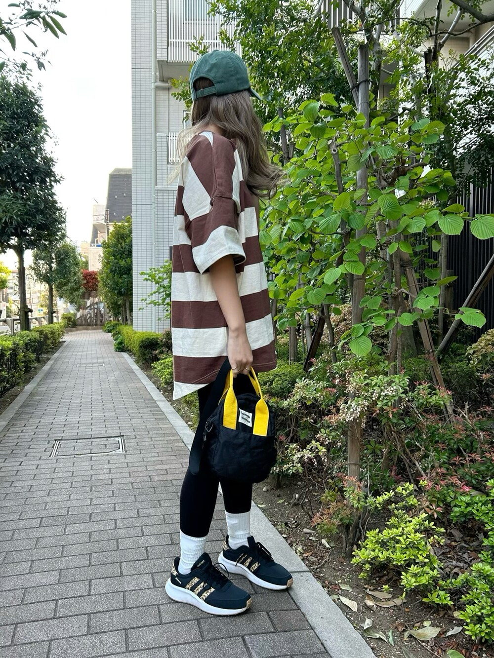 ブラック系のトートバッグ、ブラウン系のTシャツ/カットソーを着用したレディースの春コーディネートの3枚目の写真