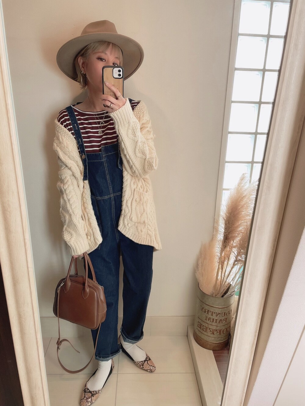 ホワイト系のカーディガン/ボレロ、ブラウン系のショルダーバッグ、ブラウン系のハットを着用したレディースの冬コーディネートの4枚目の写真