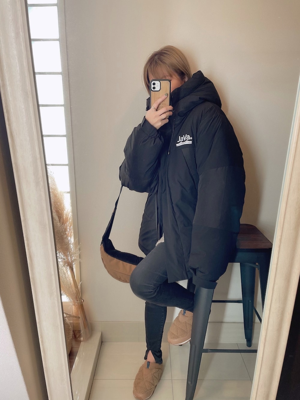 ブラック系のダウンジャケット/コート、ブラック系のデニムパンツ、ベージュ系のその他シューズを着用したレディースの秋コーディネートの4枚目の写真