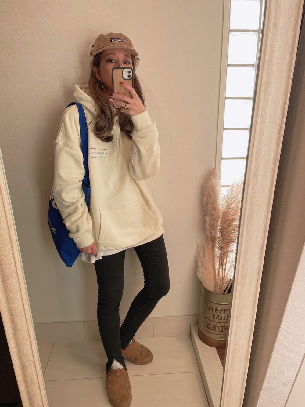 ブラック系のその他アウター、ホワイト系のパーカー、ブラック系のデニムパンツを着用したレディースの冬コーディネートの3枚目の写真