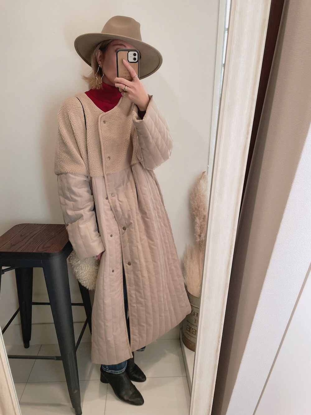 ベージュ系のノーカラーコート、ホワイト系のショルダーバッグ、ホワイト系のデニムパンツを着用したレディースの冬コーディネートの2枚目の写真