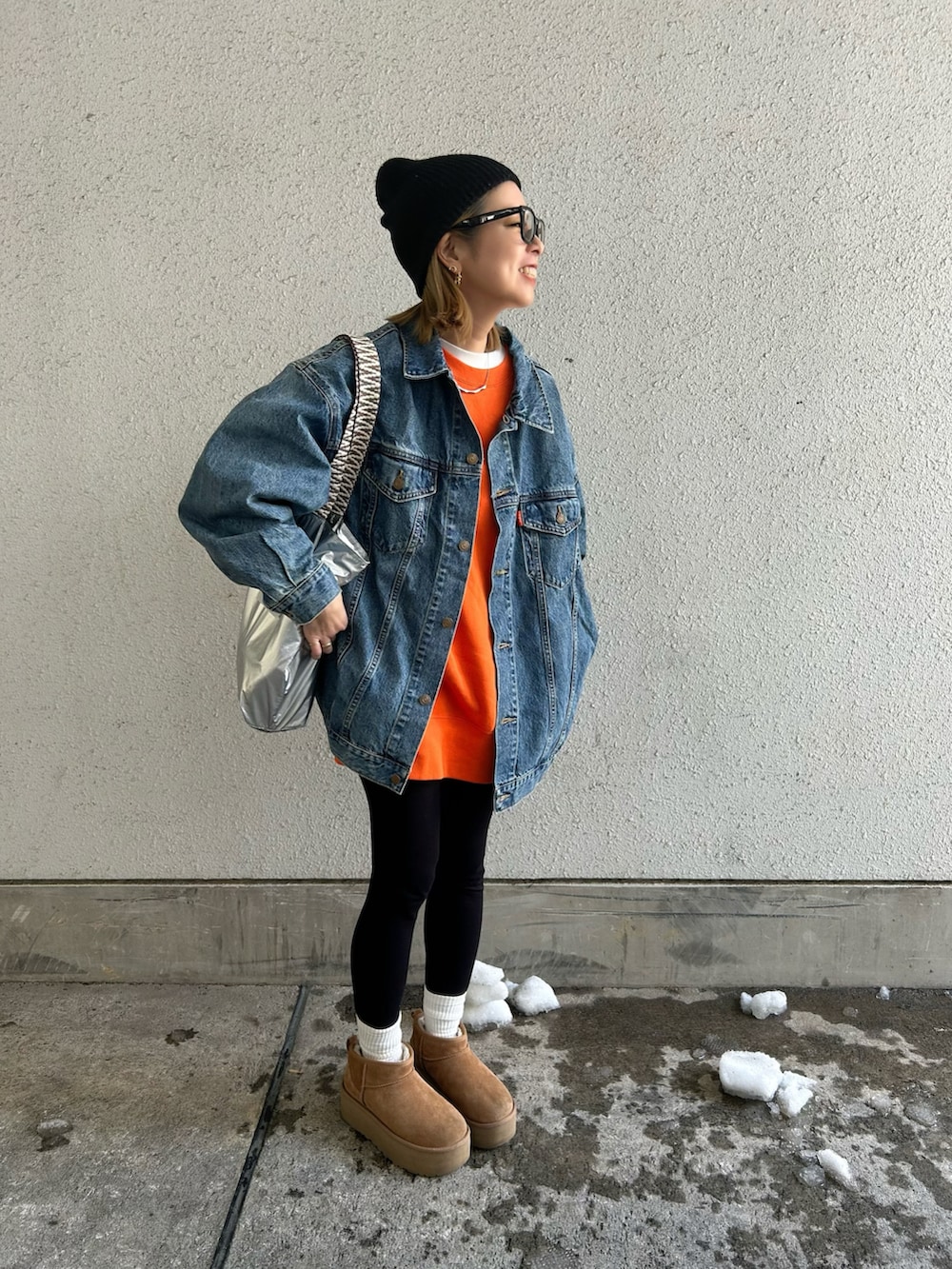 ブルー系のデニムジャケット、オレンジ系のスウェット、ブラウン系のブーツを着用したレディースの冬コーディネートの4枚目の写真
