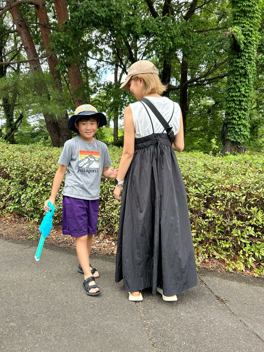 ブラック系のワンピース、ブラウン系のボディバッグ/ウエストポーチ、その他のサンダルを着用したレディースの夏コーディネートの2枚目の写真