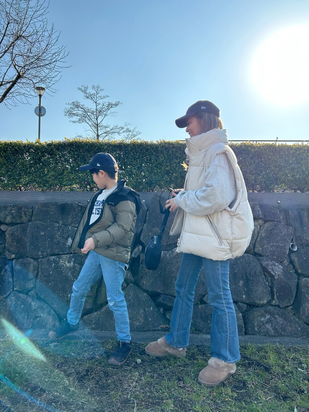 ベージュ系のダウンベスト、ホワイト系のトップス、ブルー系のデニムパンツを着用したレディースの冬コーディネートの2枚目の写真