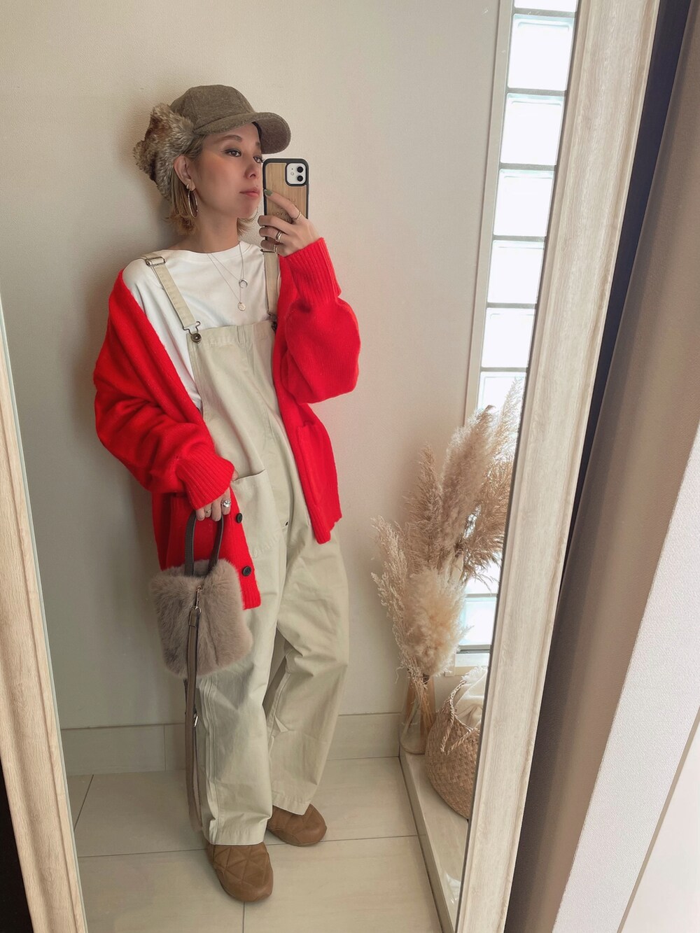 オレンジ系のカーディガン/ボレロ、ブラウン系のスニーカー、ブラウン系のキャップを着用したレディースの秋コーディネートの2枚目の写真