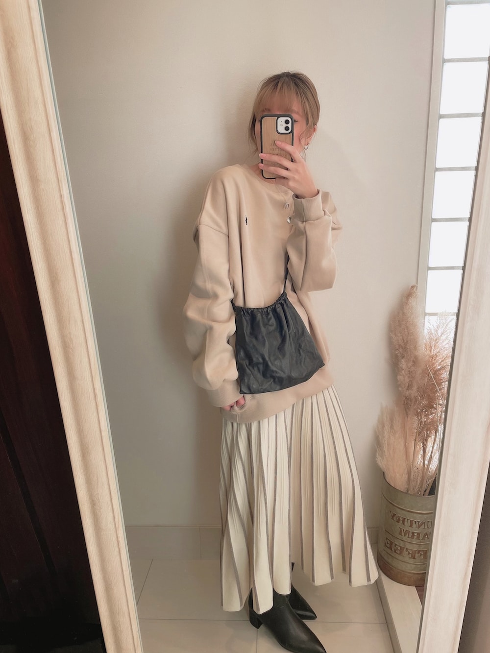 ブラック系のボディバッグ/ウエストポーチ、ブラック系のブーツを着用したレディースの冬コーディネートの2枚目の写真