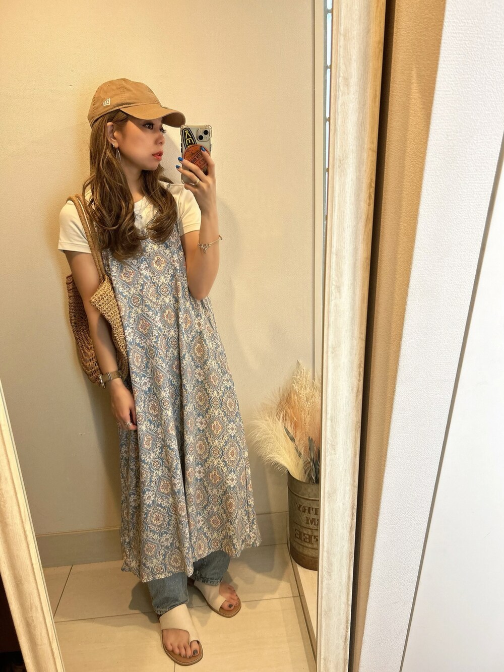 ブルー系のワンピース、ホワイト系のサンダル、ベージュ系のキャップを着用したレディースの夏コーディネートの2枚目の写真