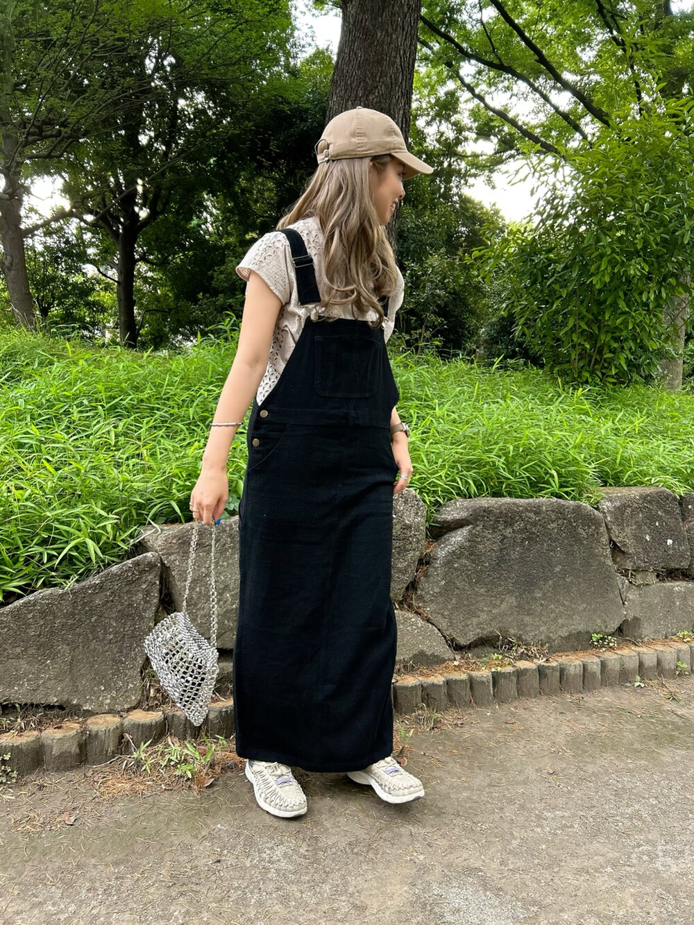 グレー系のシャツ/ブラウス、ベージュ系のスニーカー、ベージュ系のキャップを着用したレディースの夏コーディネートの2枚目の写真