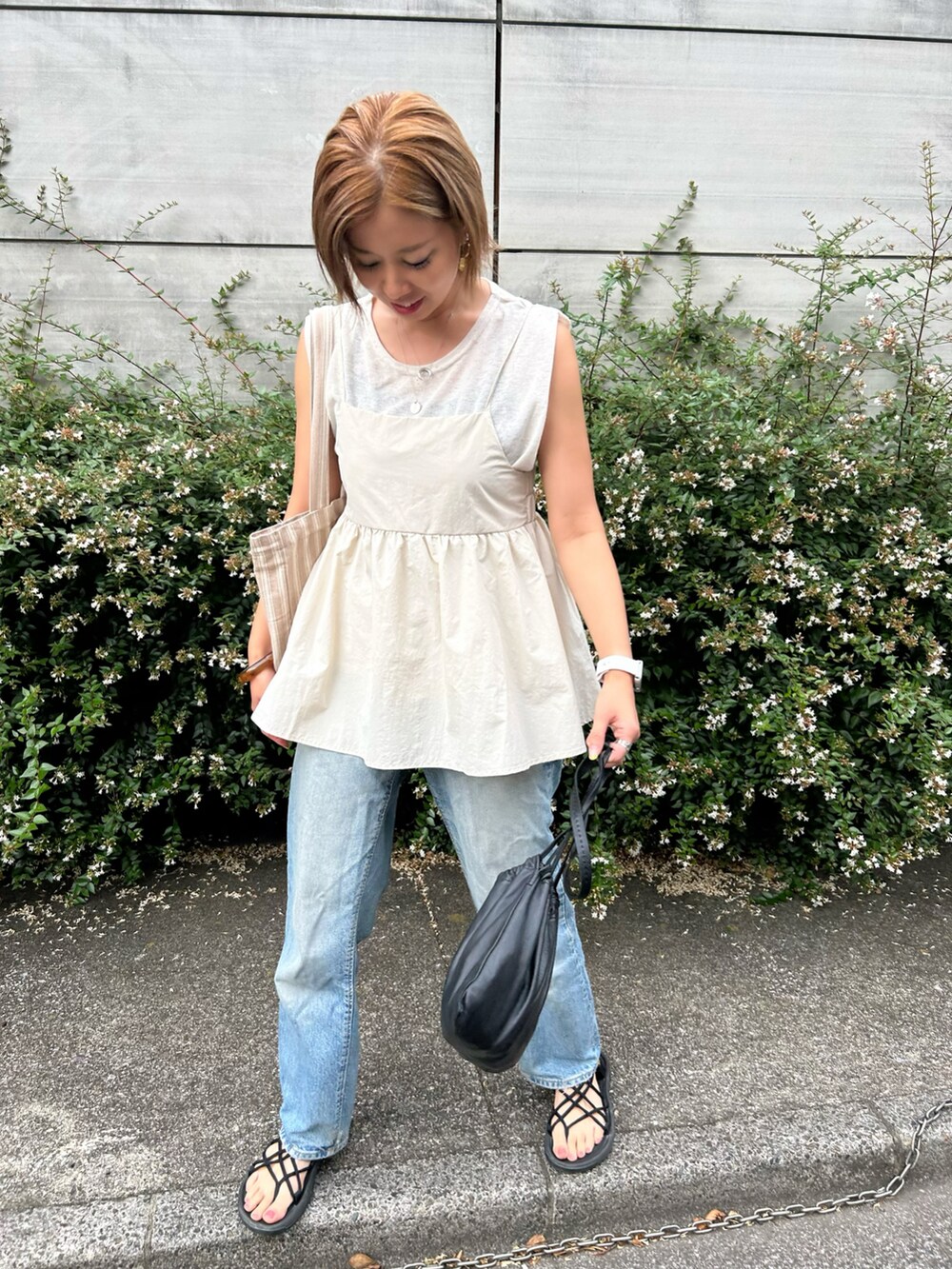 ホワイト系のキャミソール、ブラック系のサンダル、ブラック系のボディバッグ/ウエストポーチを着用したレディースの夏コーディネートの2枚目の写真