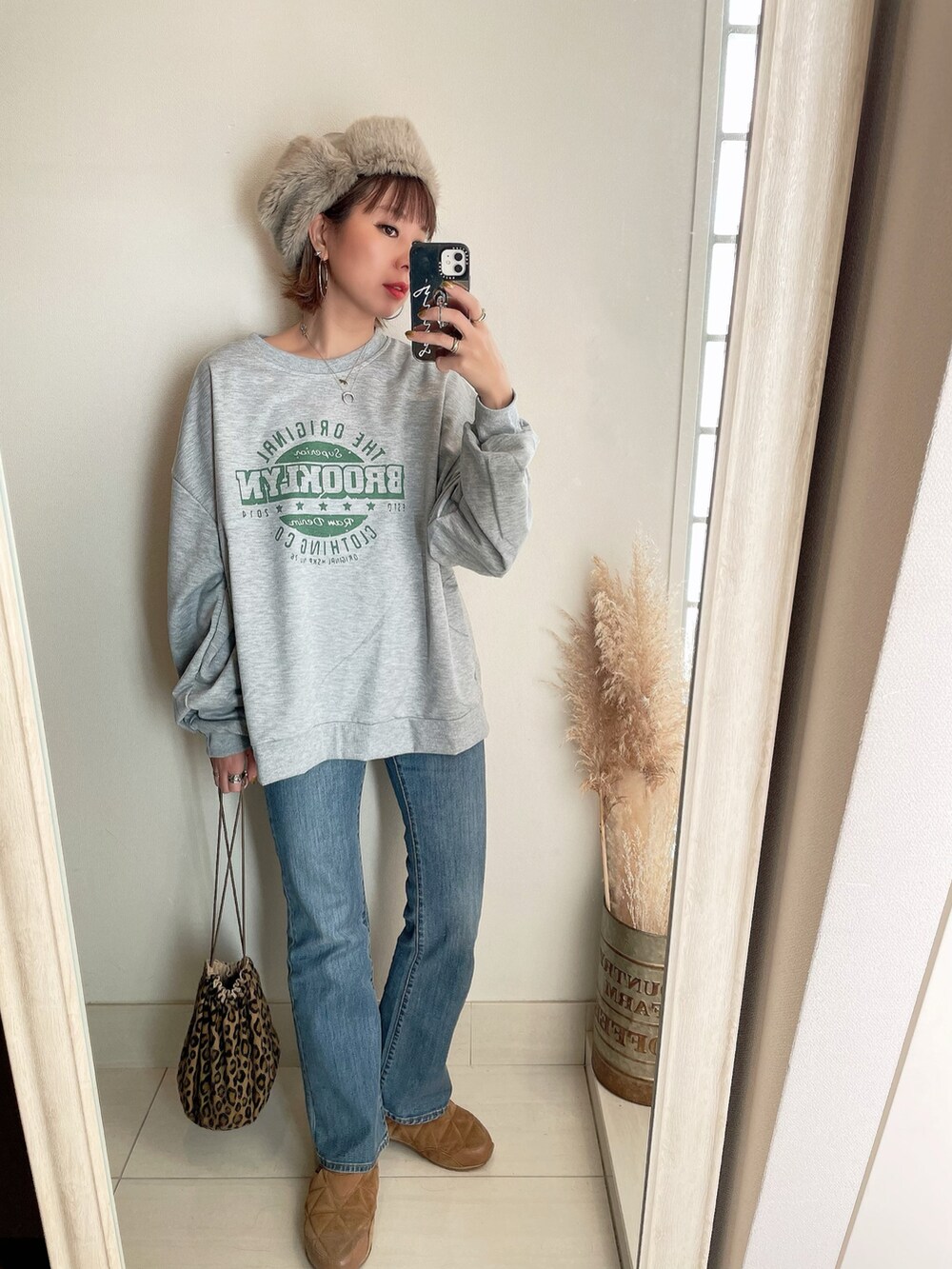 グレー系のスウェット、グリーン系のブルゾン、ブルー系のデニムパンツを着用したレディースの冬コーディネートの3枚目の写真