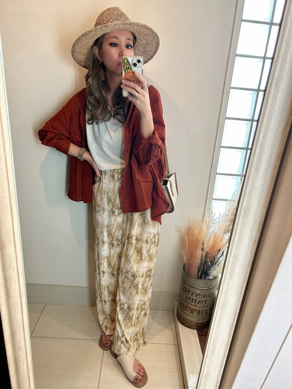 ブラウン系のシャツ/ブラウス、ホワイト系のサンダル、ベージュ系のハットを着用したレディースの春コーディネートの2枚目の写真