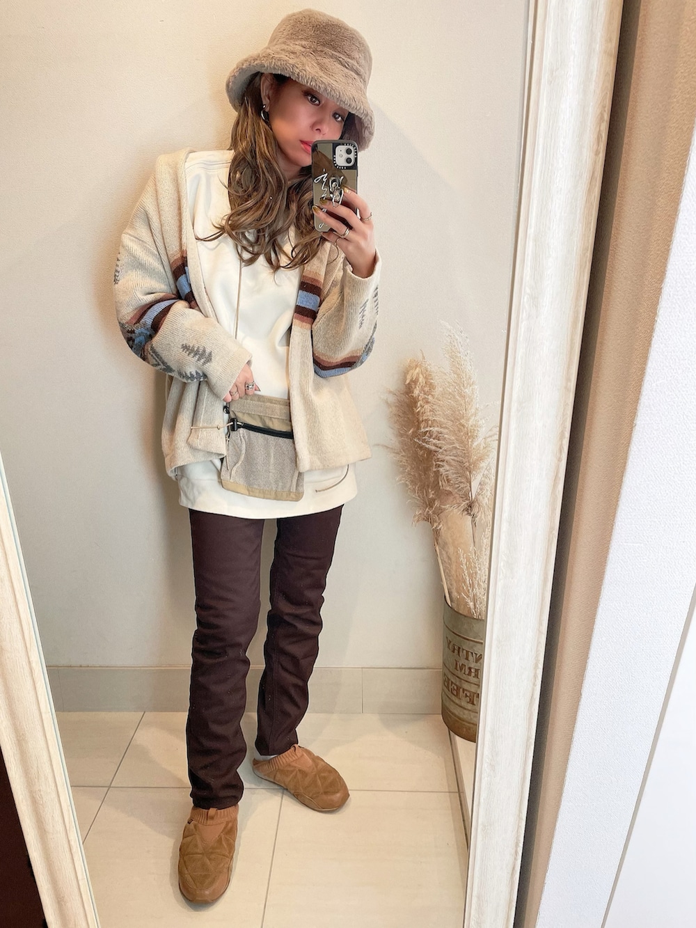ベージュ系のカーディガン/ボレロ、ブラウン系のスニーカー、ブラウン系のハットを着用したレディースの冬コーディネートの2枚目の写真