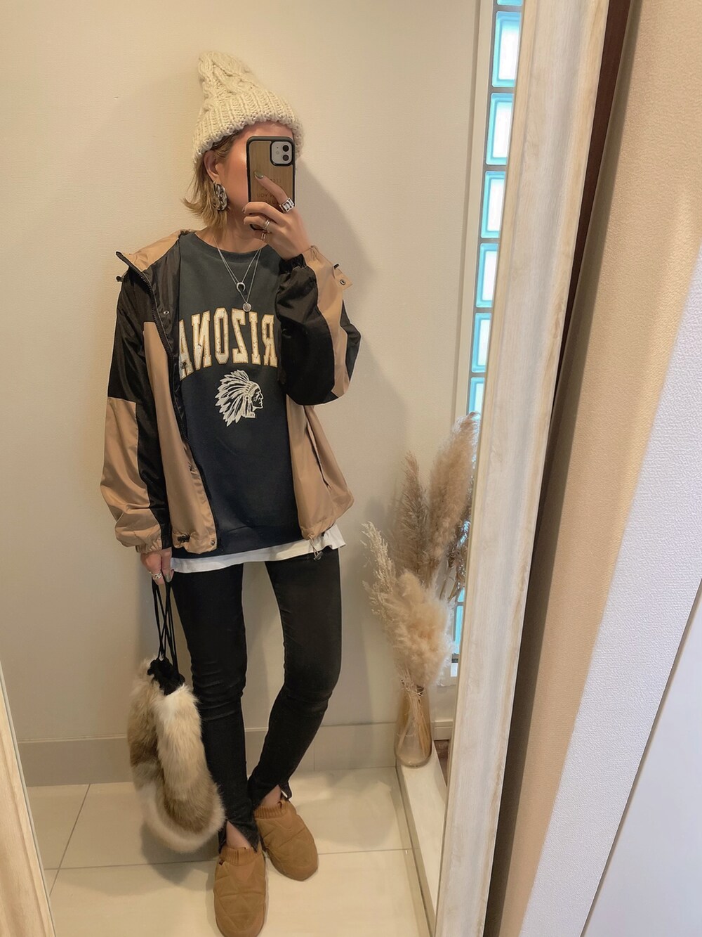 グレー系のスウェット、ブラック系のデニムパンツ、ブラウン系のスニーカーを着用したレディースの秋コーディネートの2枚目の写真