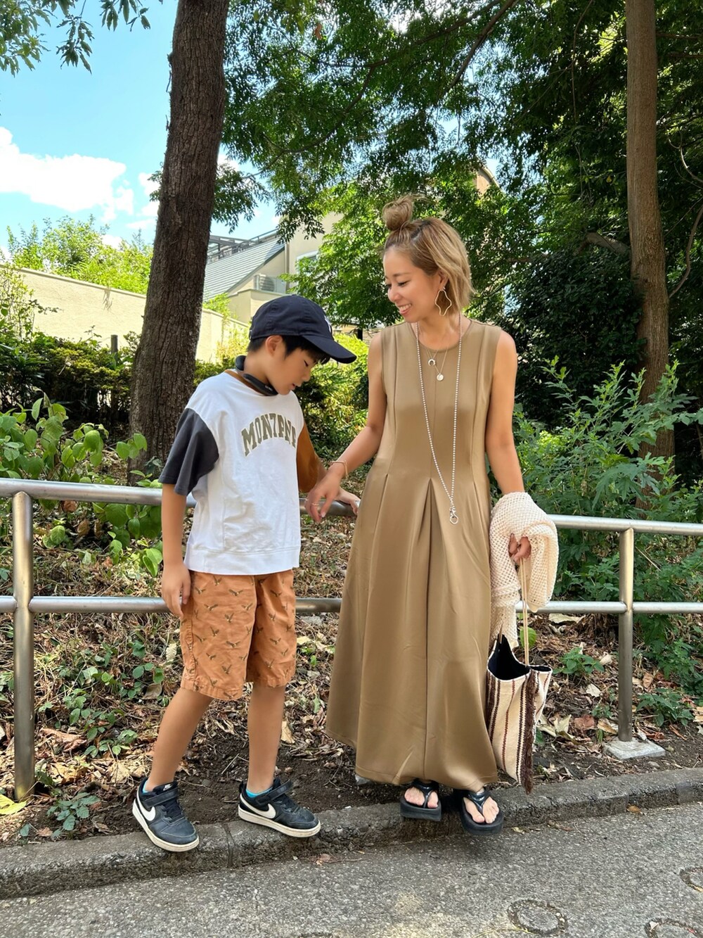 ベージュ系のワンピース、ブラック系のサンダルを着用したレディースの夏コーディネートの3枚目の写真