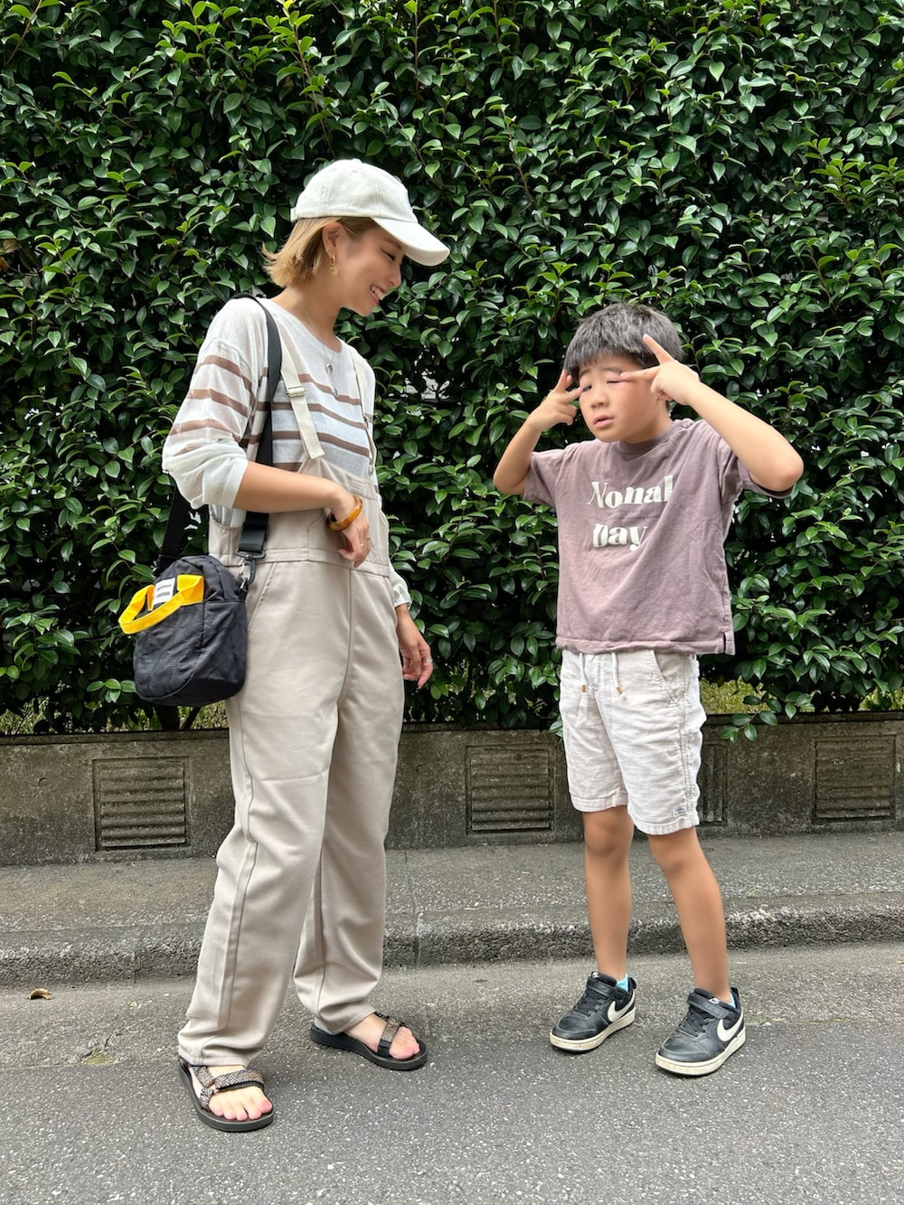 ホワイト系のTシャツ/カットソー、ブラック系のトートバッグ、ブラック系のサンダルを着用したレディースの夏コーディネートの2枚目の写真