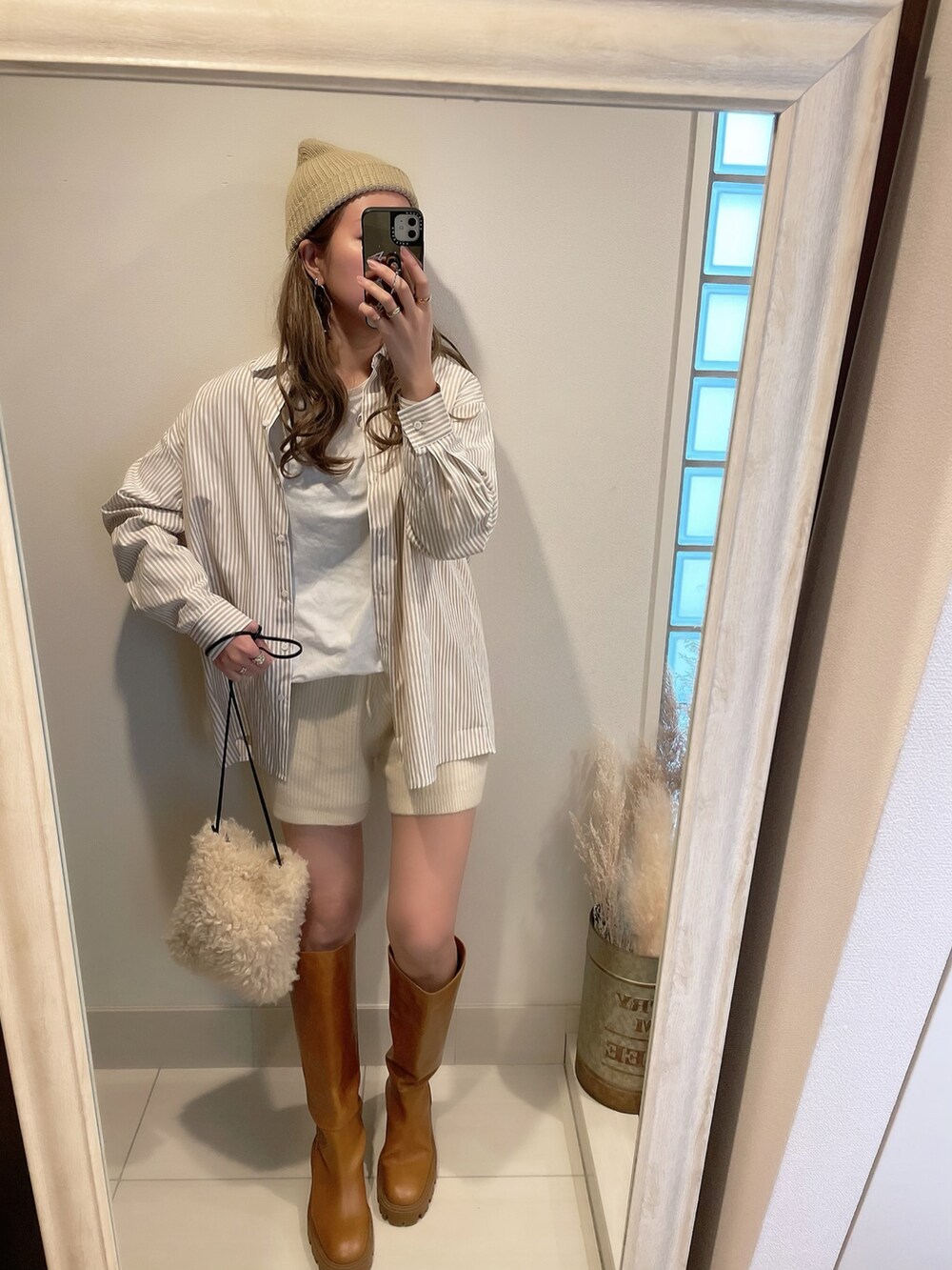 ベージュ系のシャツ/ブラウス、ホワイト系のショルダーバッグ、ブラウン系のブーツを着用したレディースの冬コーディネートの2枚目の写真