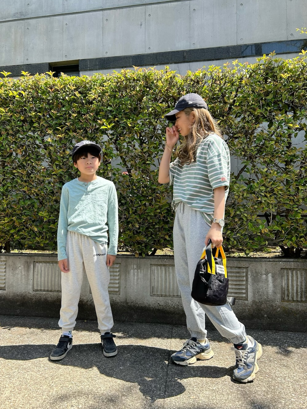 グリーン系のTシャツ/カットソー、ブラック系のトートバッグ、ブルー系のスニーカーを着用したレディースの春コーディネートの2枚目の写真