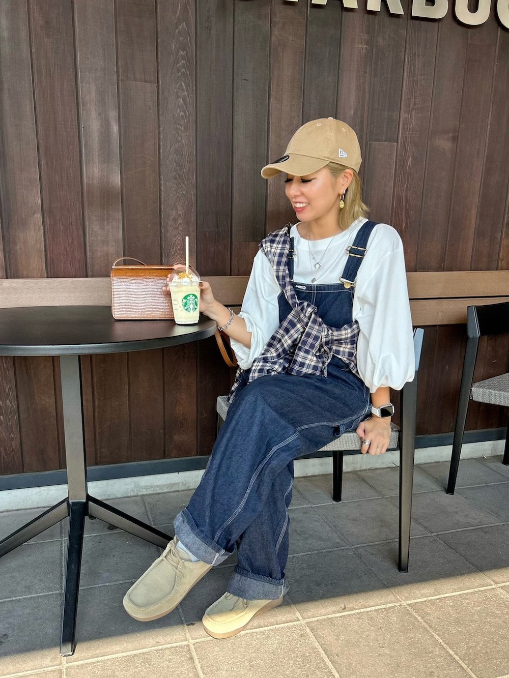 ホワイト系のTシャツ/カットソー、ブルー系のサロペット/オーバーオール、ベージュ系のモカシン/デッキシューズを着用したレディースの秋コーディネートの2枚目の写真