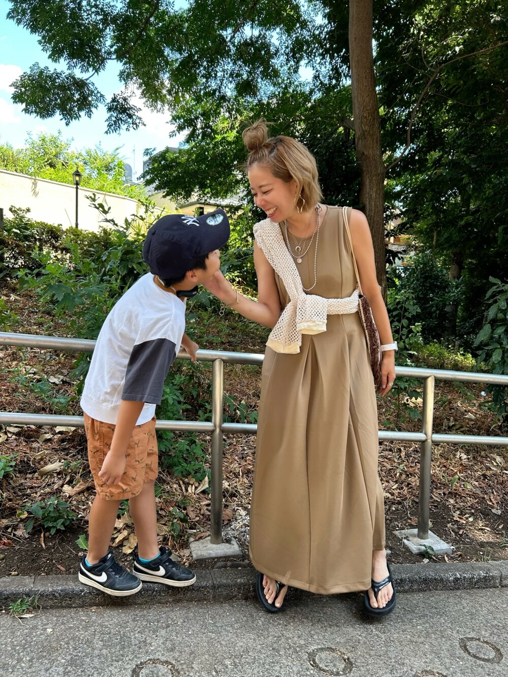 ベージュ系のワンピース、ブラック系のサンダルを着用したレディースの夏コーディネートの2枚目の写真