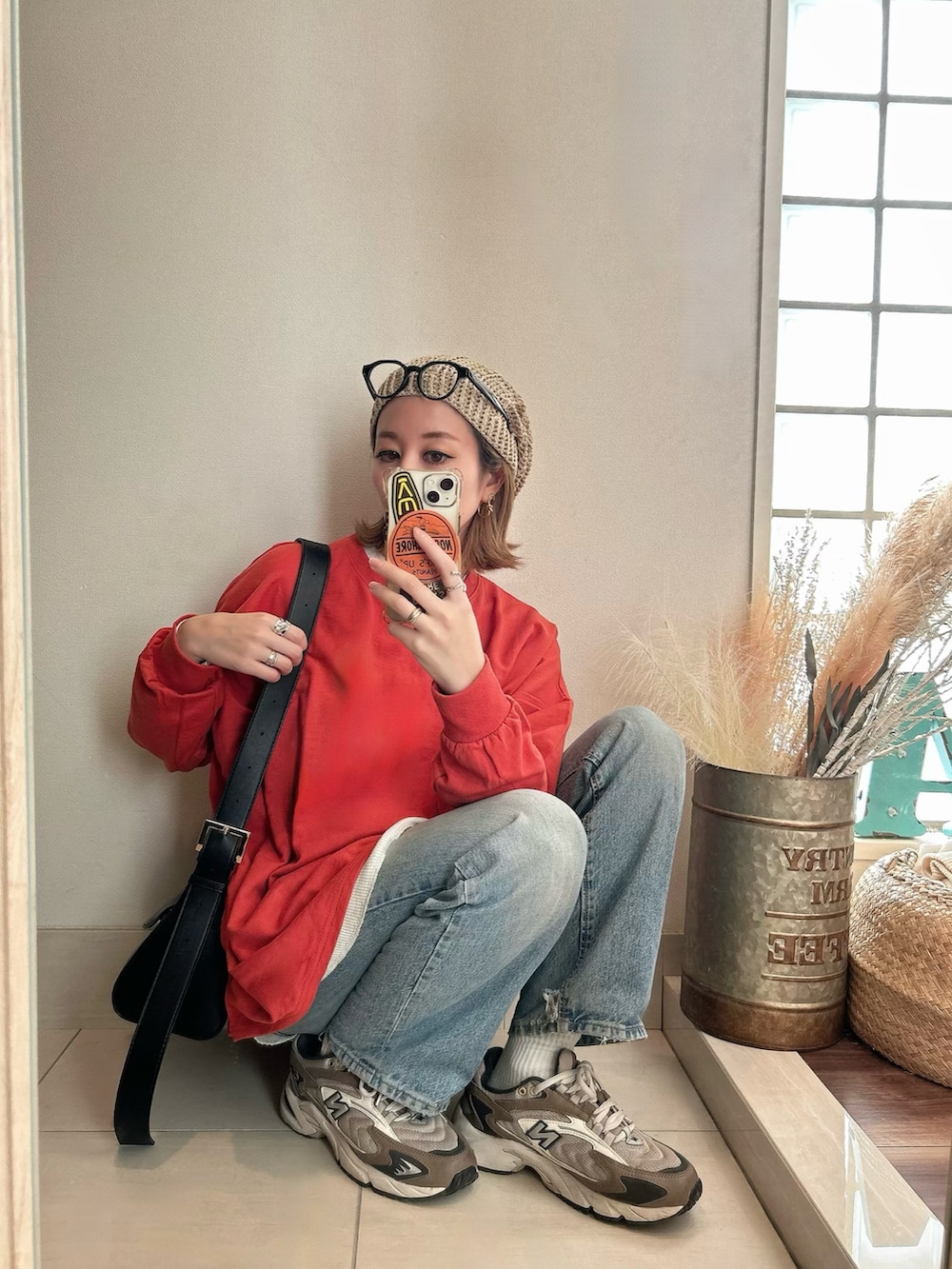 ブラウン系のスニーカー、レッド系のTシャツ/カットソー、ベージュ系のニットキャップ/ビーニーを着用したレディースの春コーディネートの2枚目の写真