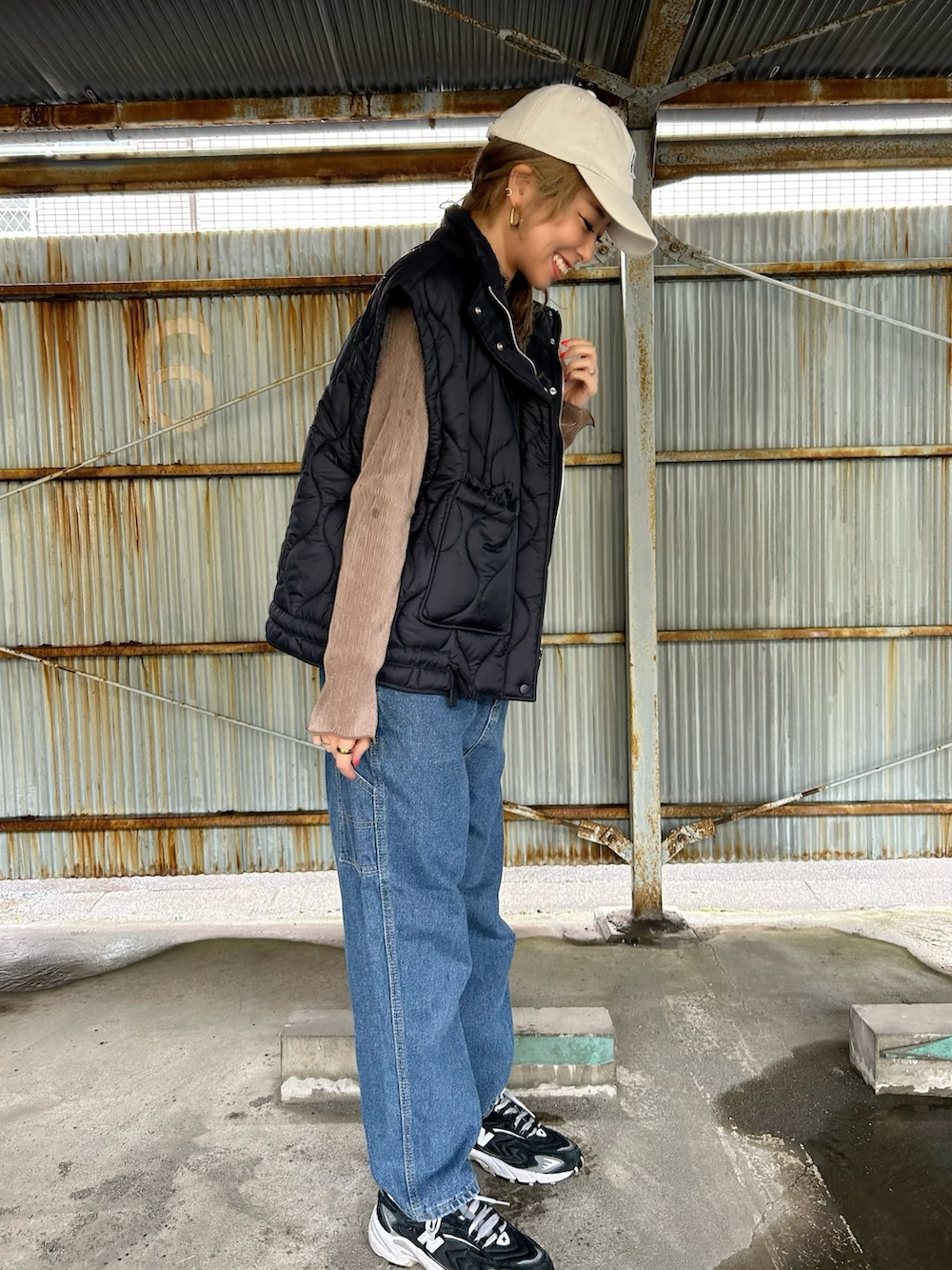 ブラウン系のTシャツ/カットソー、ブラック系のスニーカー、ベージュ系のショルダーバッグを着用したレディースの春コーディネートの5枚目の写真