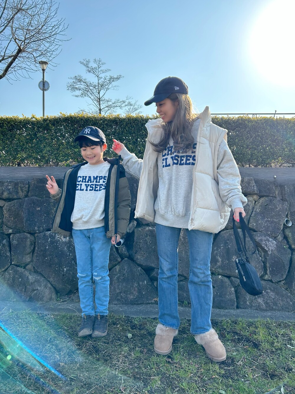 ベージュ系のダウンベスト、ホワイト系のトップス、ブルー系のデニムパンツを着用したレディースの冬コーディネートの3枚目の写真