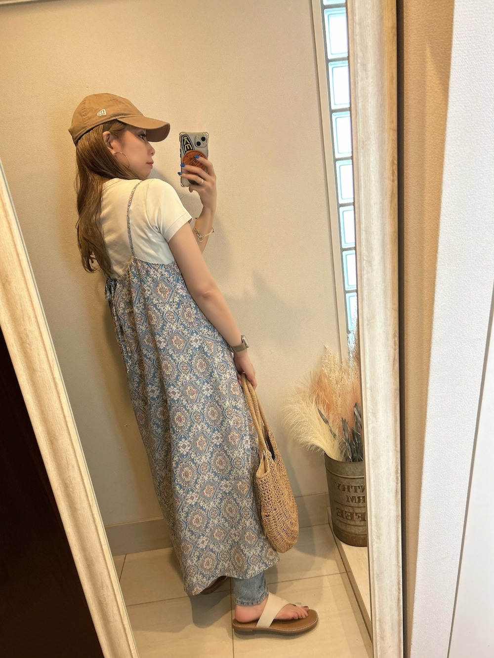 ブルー系のワンピース、ホワイト系のサンダル、ベージュ系のキャップを着用したレディースの夏コーディネートの3枚目の写真