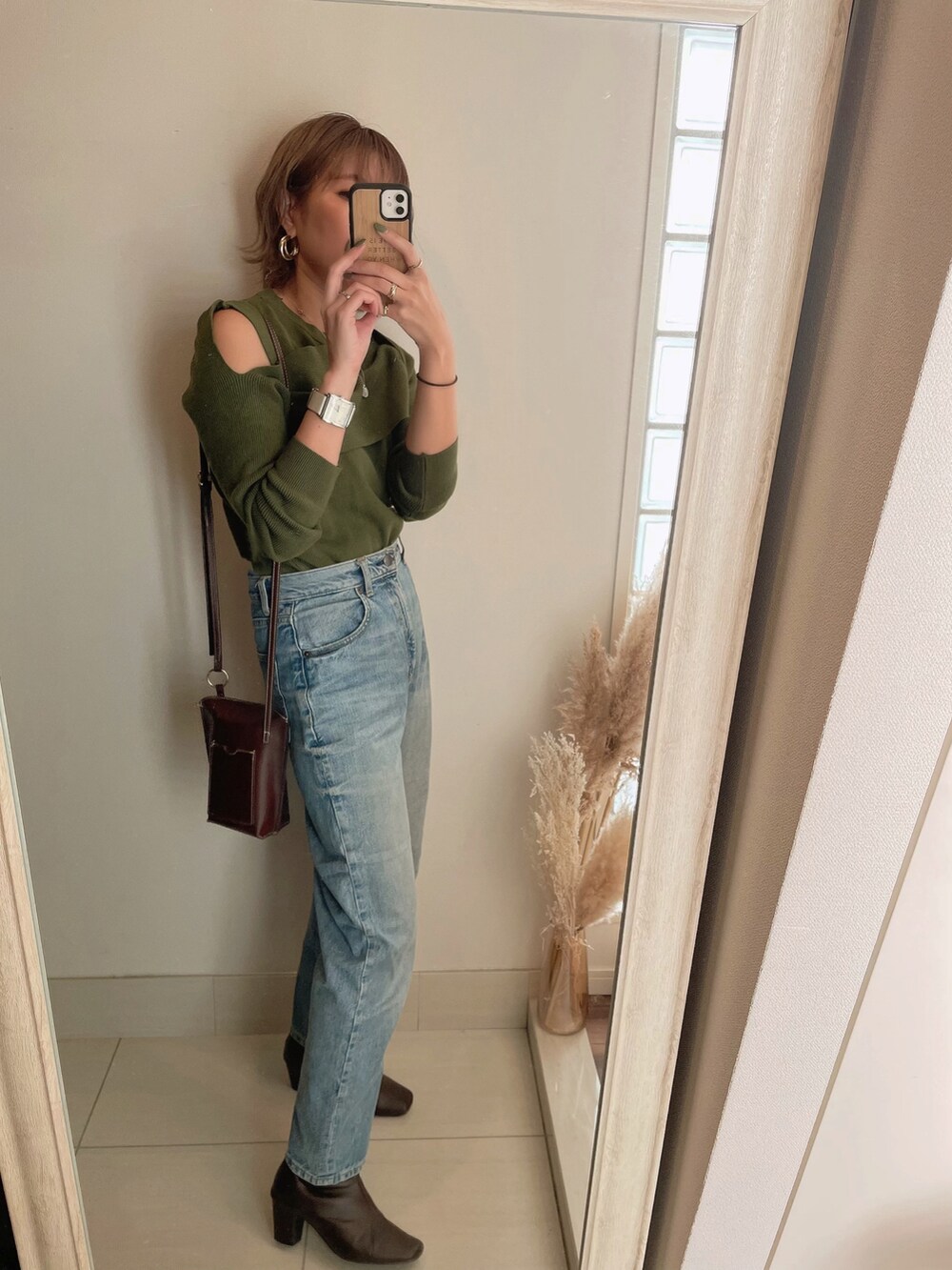 ブラウン系のチェスターコート、ブラウン系のブーツを着用したレディースの秋コーディネートの3枚目の写真