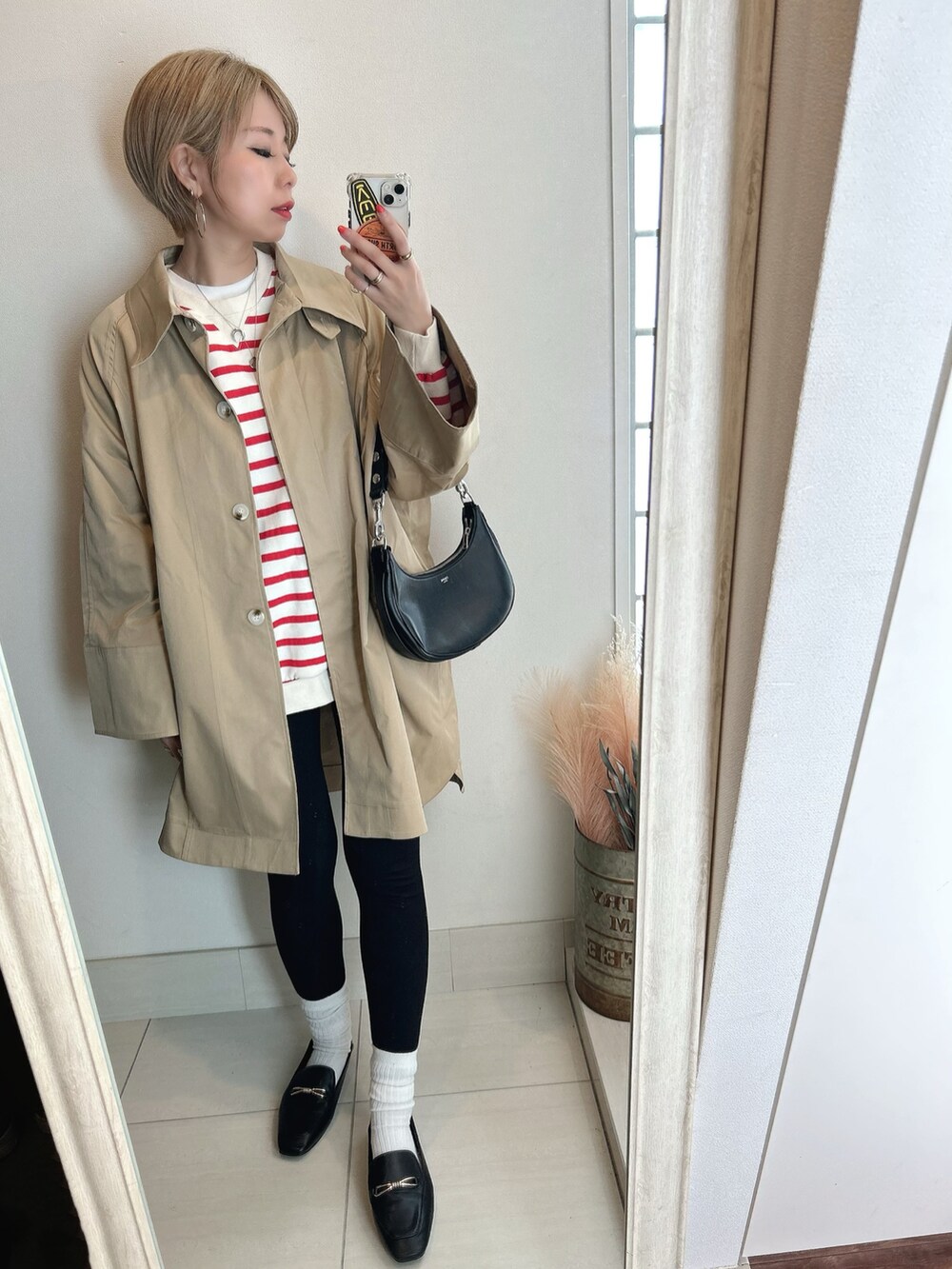 ベージュ系のステンカラーコートを着用したレディースの春コーディネートの4枚目の写真