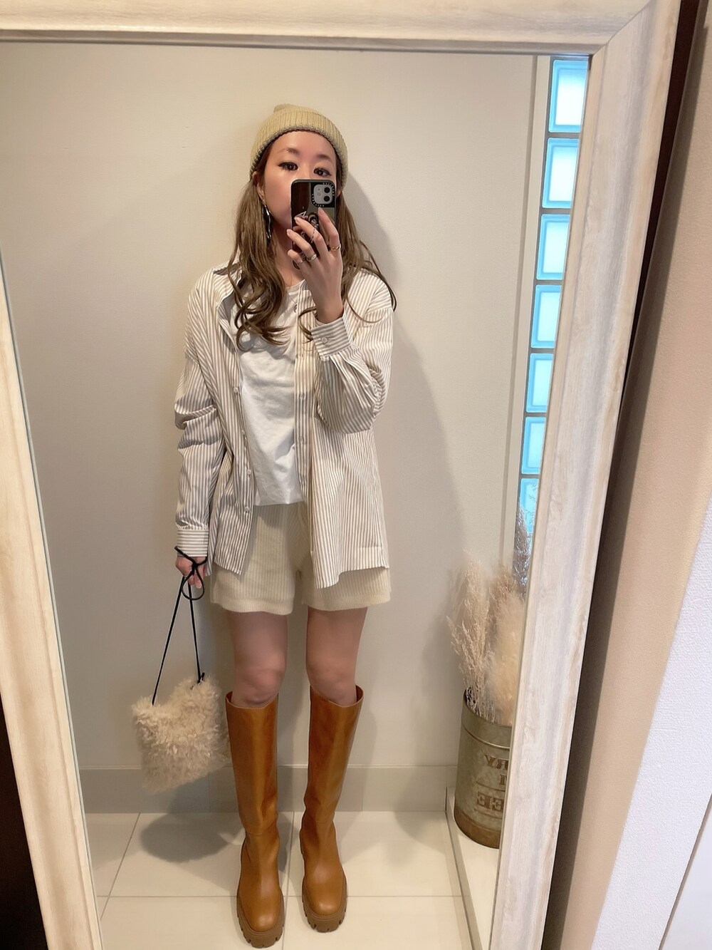 ベージュ系のシャツ/ブラウス、ホワイト系のショルダーバッグ、ブラウン系のブーツを着用したレディースの冬コーディネートの3枚目の写真