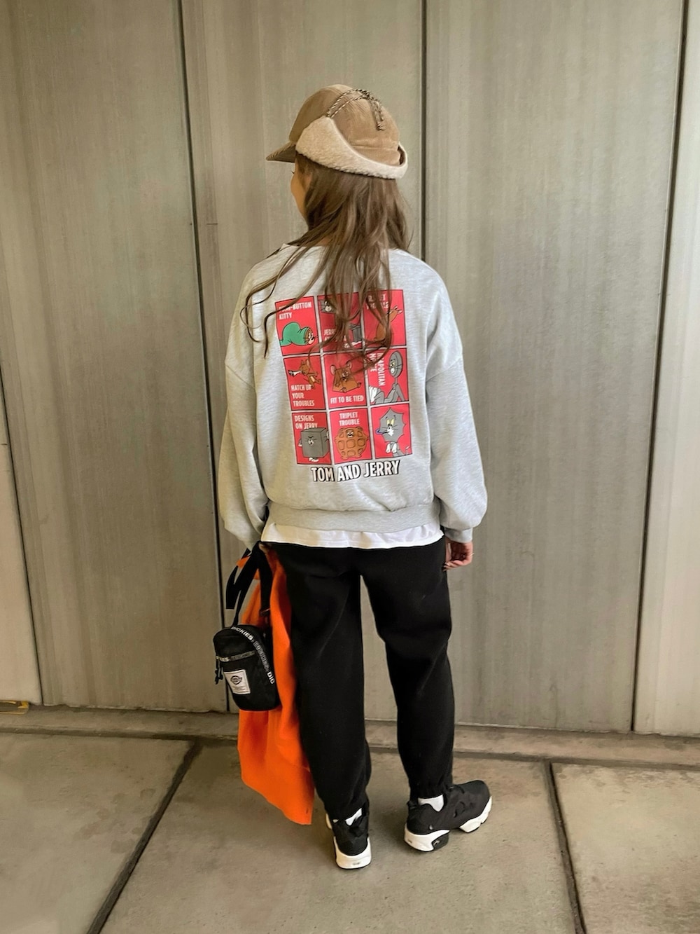 ブラック系のスニーカー、ブラック系のショルダーバッグ、ベージュ系のキャップを着用したレディースの冬コーディネートの3枚目の写真