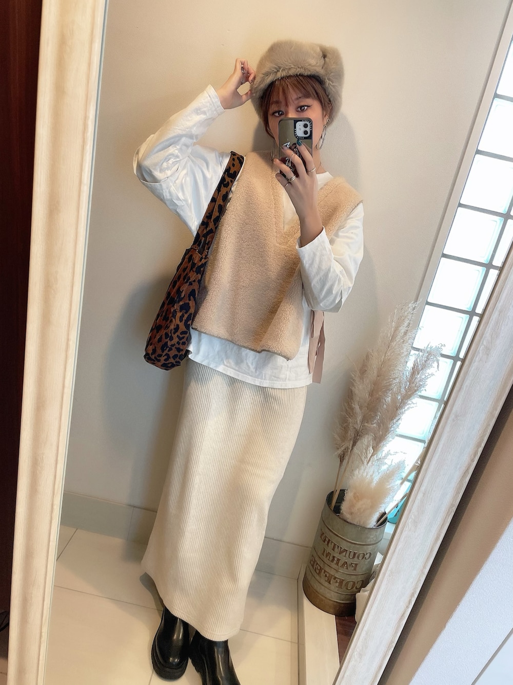 ホワイト系のベスト、ベージュ系のスカート、ベージュ系の帽子を着用したレディースの冬コーディネートの4枚目の写真