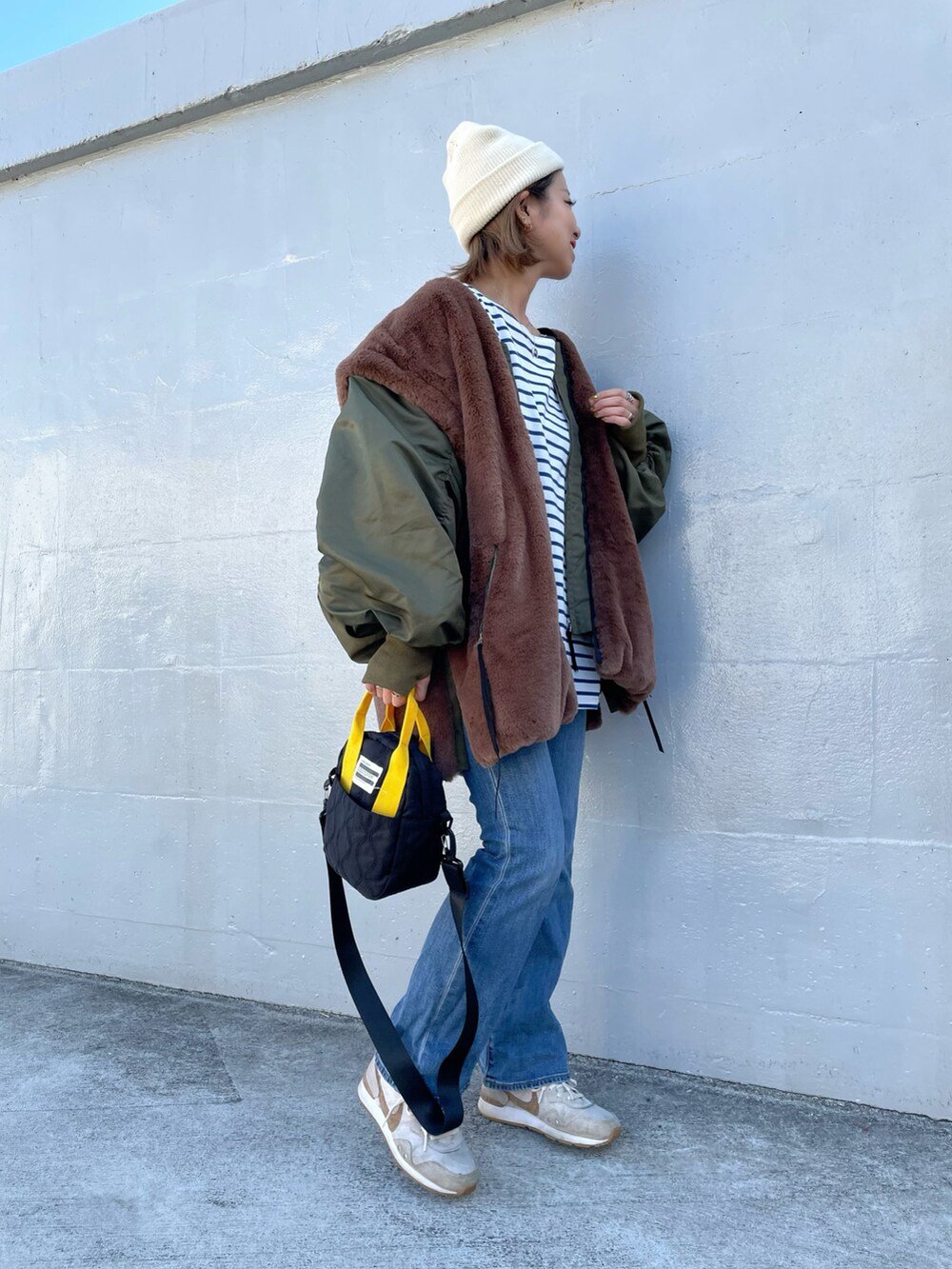 グリーン系のMA-1、ブラック系のトートバッグ、ベージュ系のスニーカーを着用したレディースの秋コーディネートの2枚目の写真
