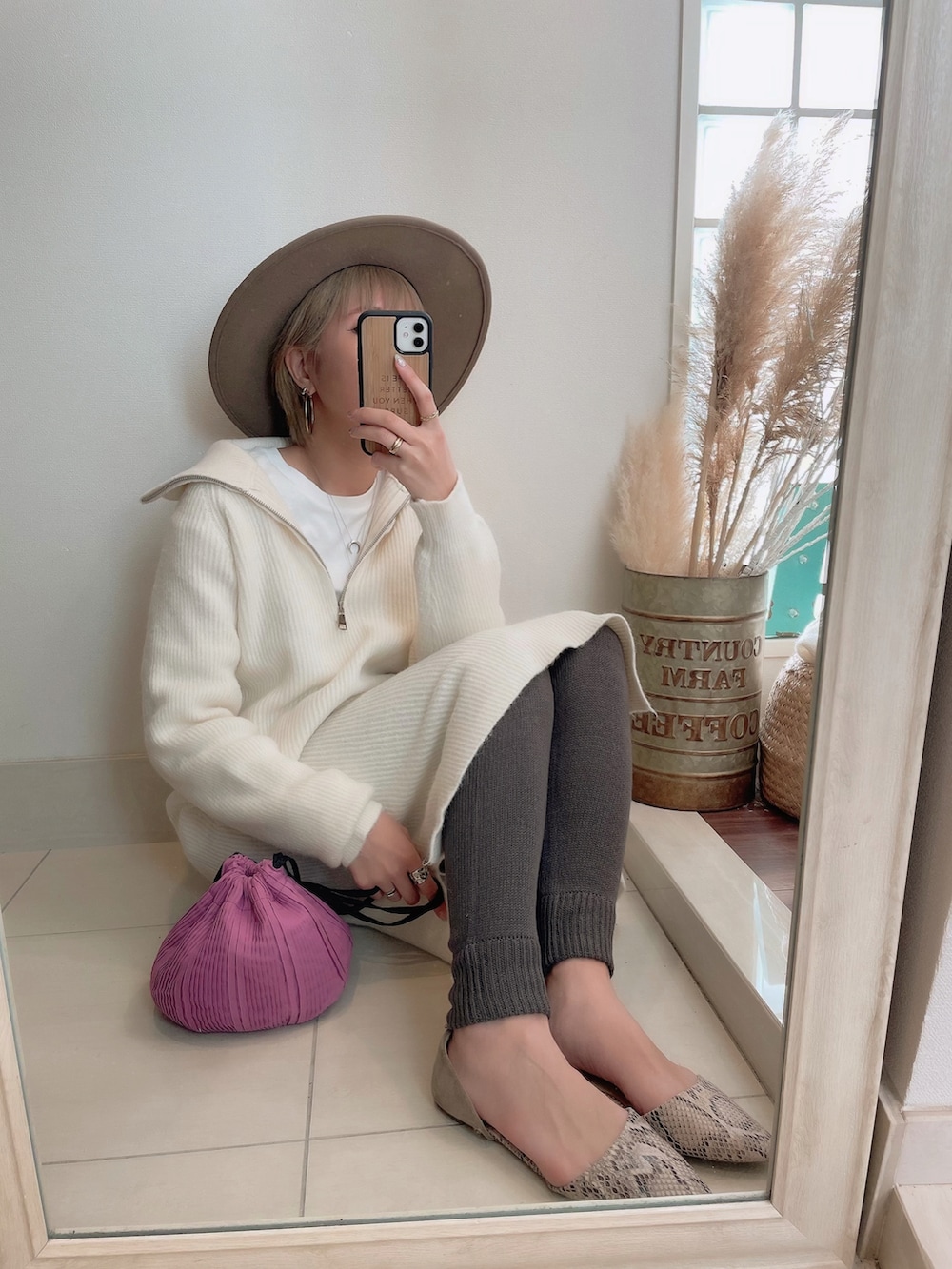 パープル系のショルダーバッグ、ブラウン系のハットを着用したレディースの春コーディネートの2枚目の写真