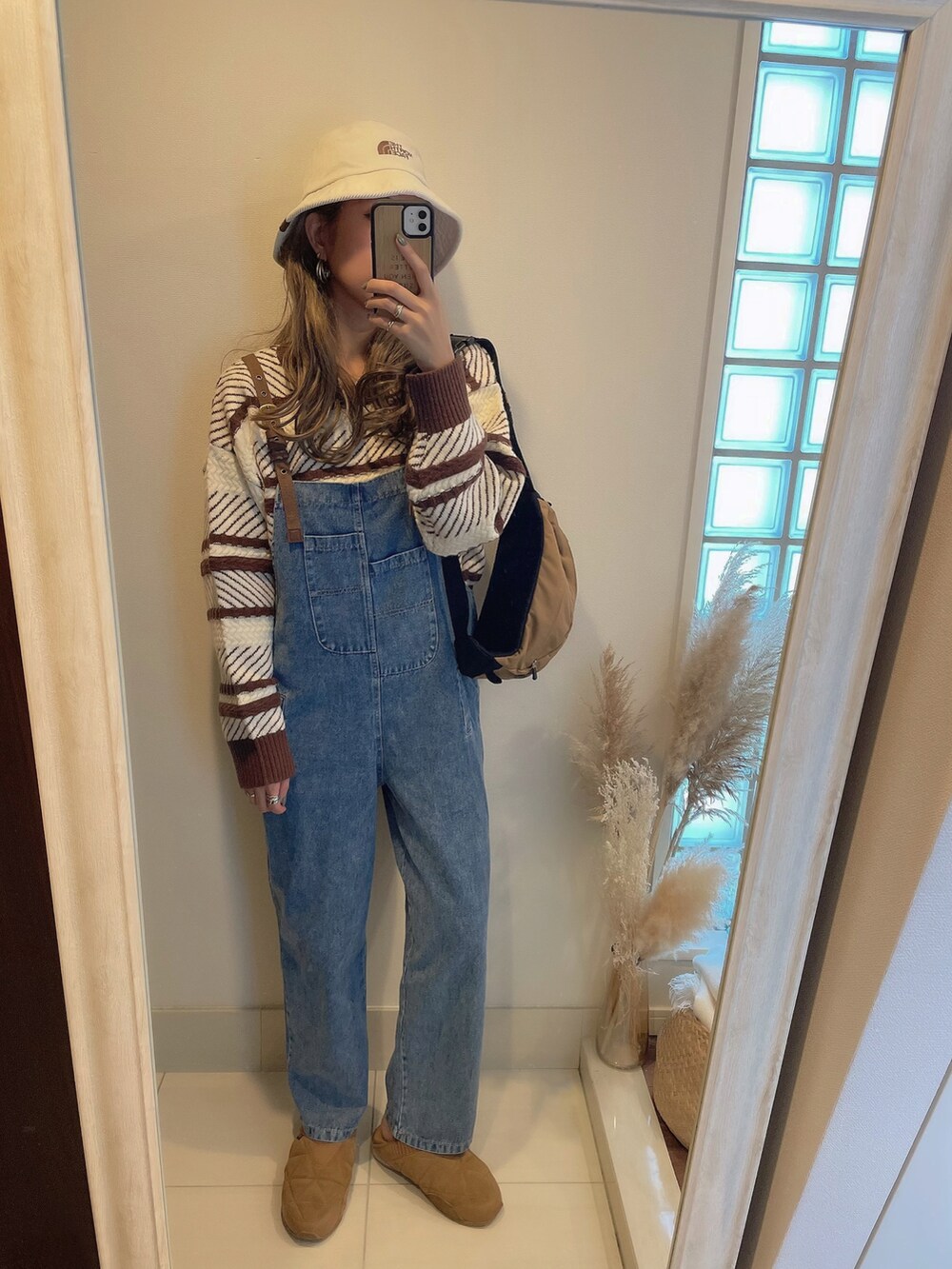 ブラウン系のニット/セーター、ブラウン系のスニーカー、ブラウン系のボディバッグ/ウエストポーチを着用したレディースの秋コーディネートの2枚目の写真