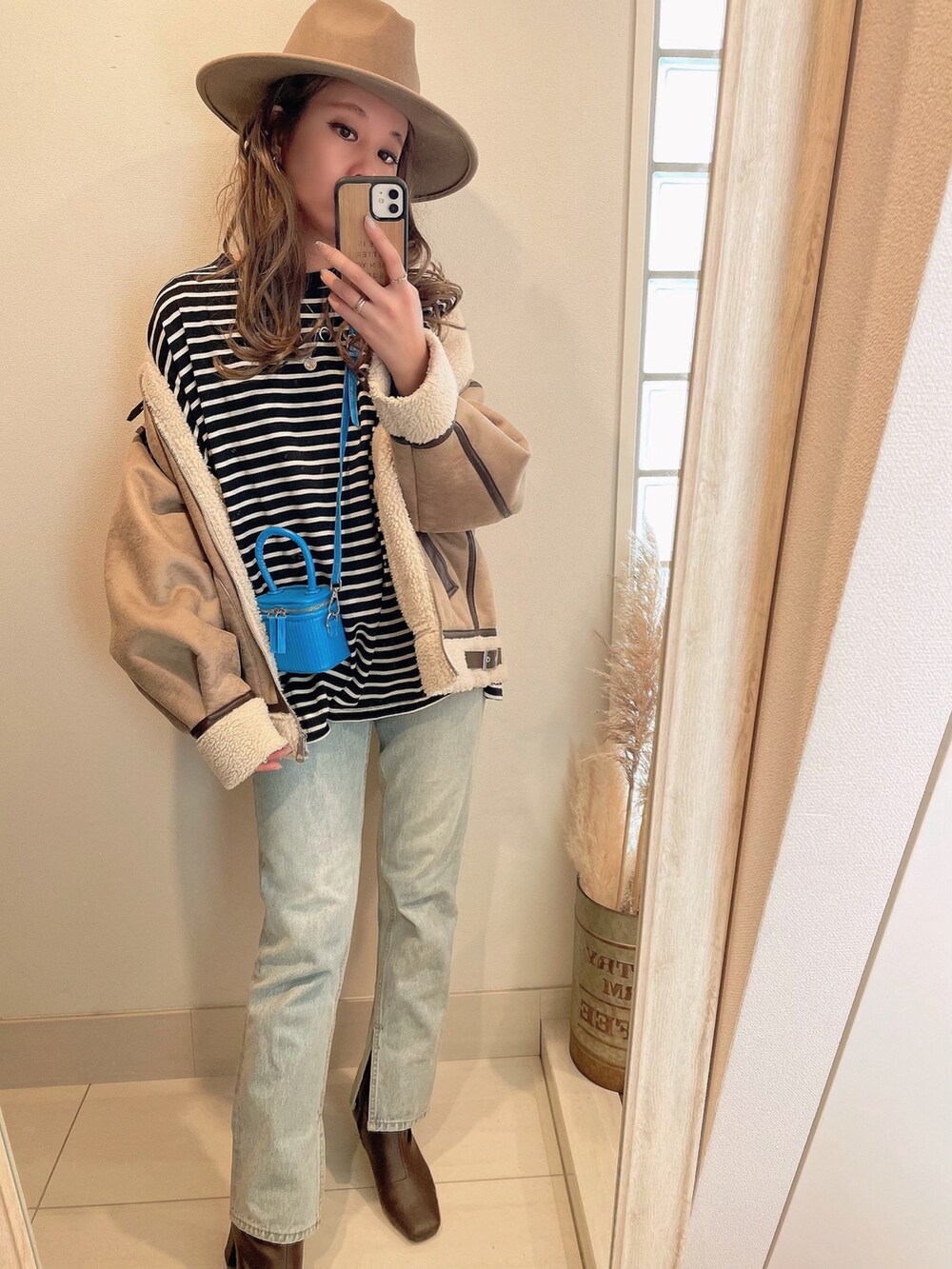 ベージュ系のブルゾン、ブラック系のTシャツ/カットソー、ブラウン系のブーツを着用したレディースの冬コーディネートの3枚目の写真