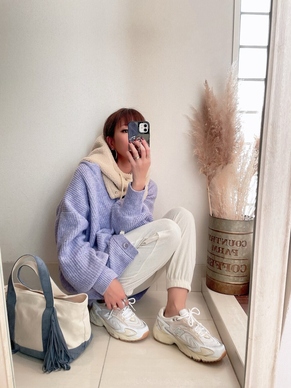 パープル系のカーディガン/ボレロ、ホワイト系のスニーカー、ベージュ系のマフラーを着用したレディースの冬コーディネートの3枚目の写真