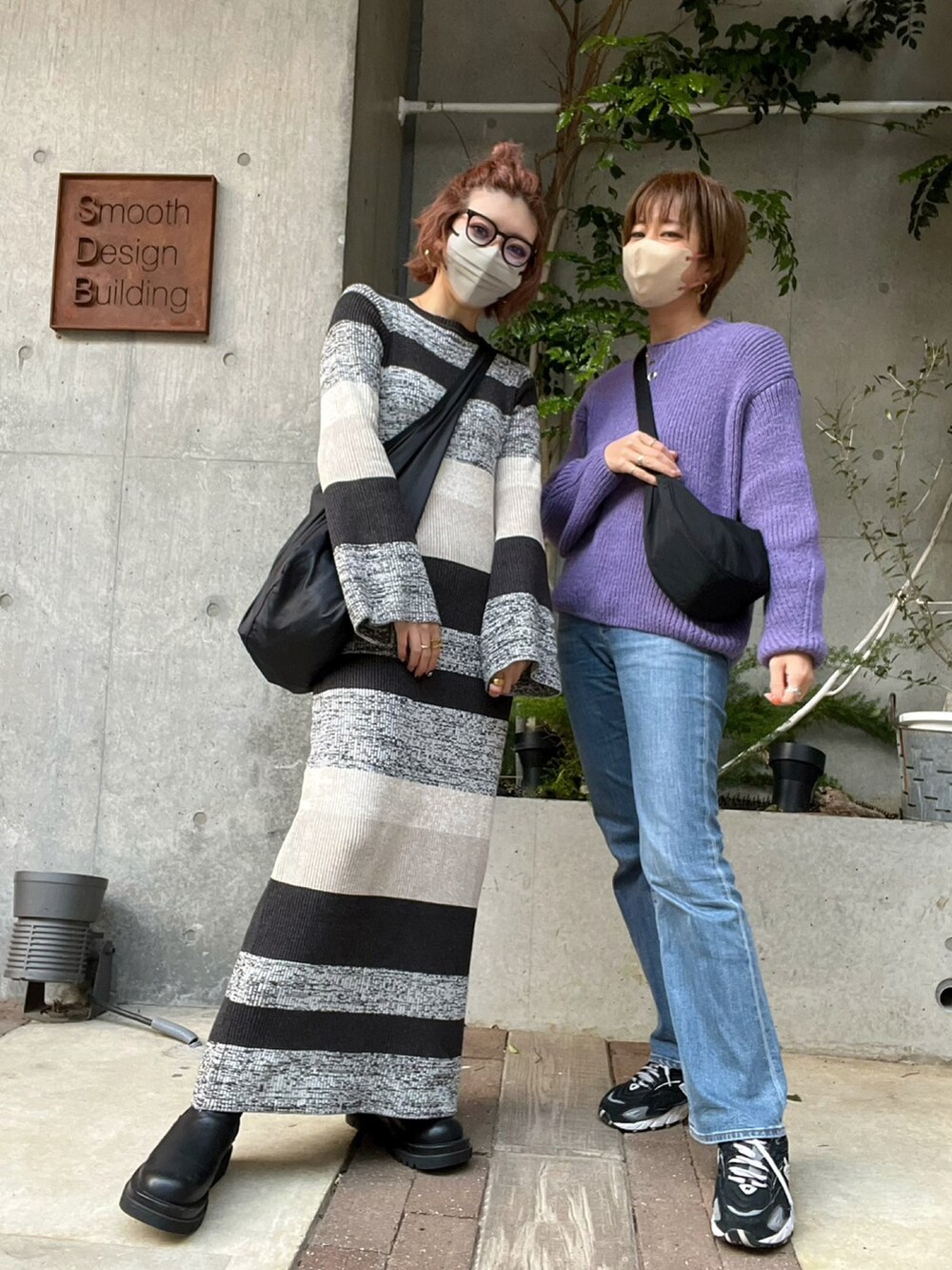 ブルー系のニット/セーター、ブラック系のショルダーバッグ、ブルー系のデニムパンツを着用したレディースの冬コーディネートの3枚目の写真