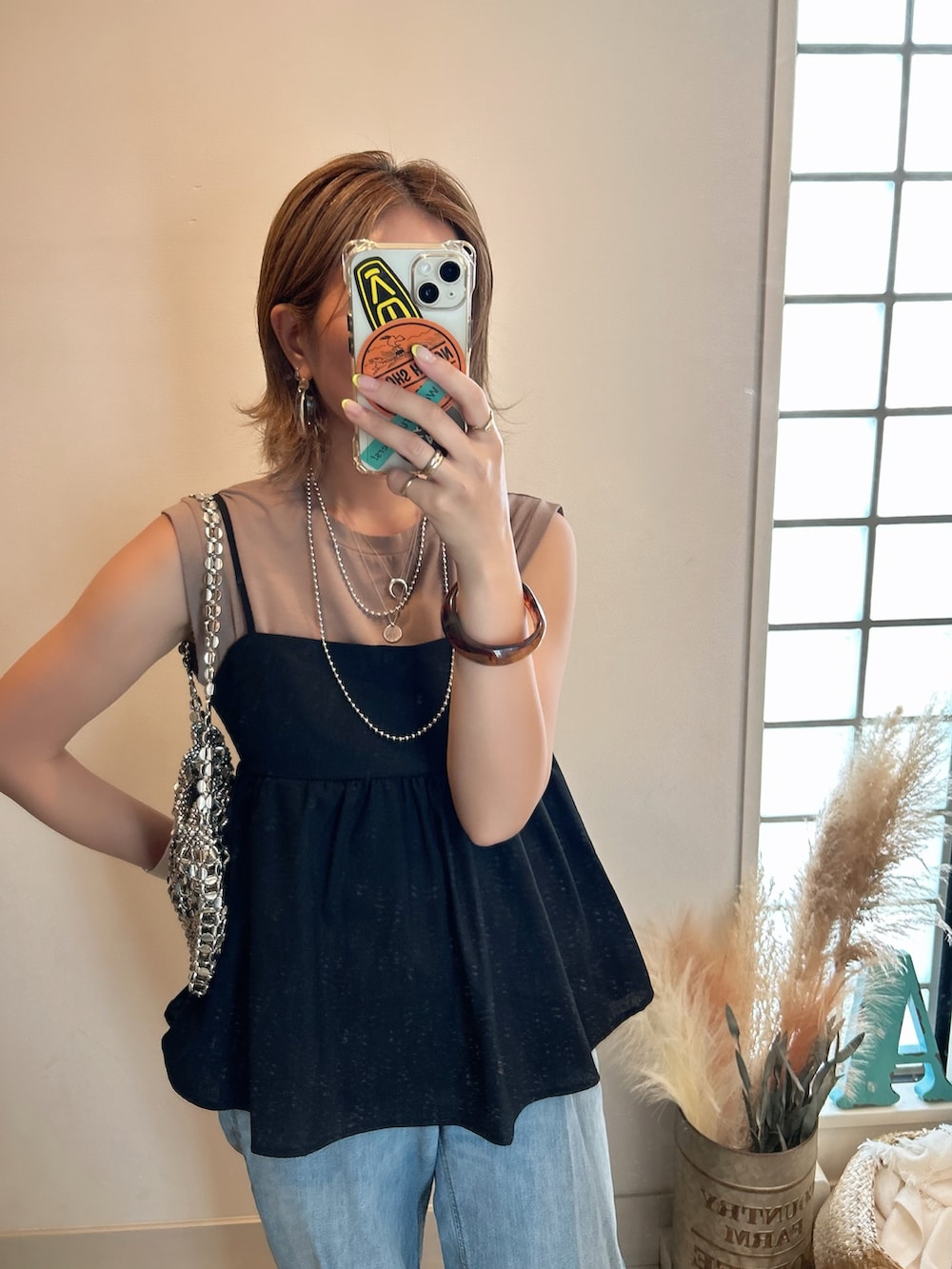 ブラック系のキャミソール、ブルー系のデニムパンツを着用したレディースの夏コーディネートの3枚目の写真