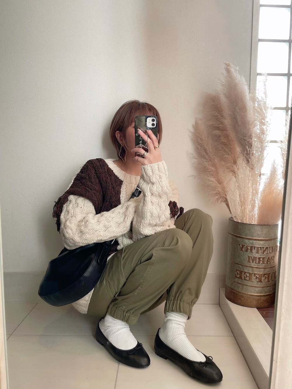 ホワイト系のニット/セーター、グリーン系のカーゴパンツ、ブラック系のバレエシューズを着用したレディースの冬コーディネートの3枚目の写真