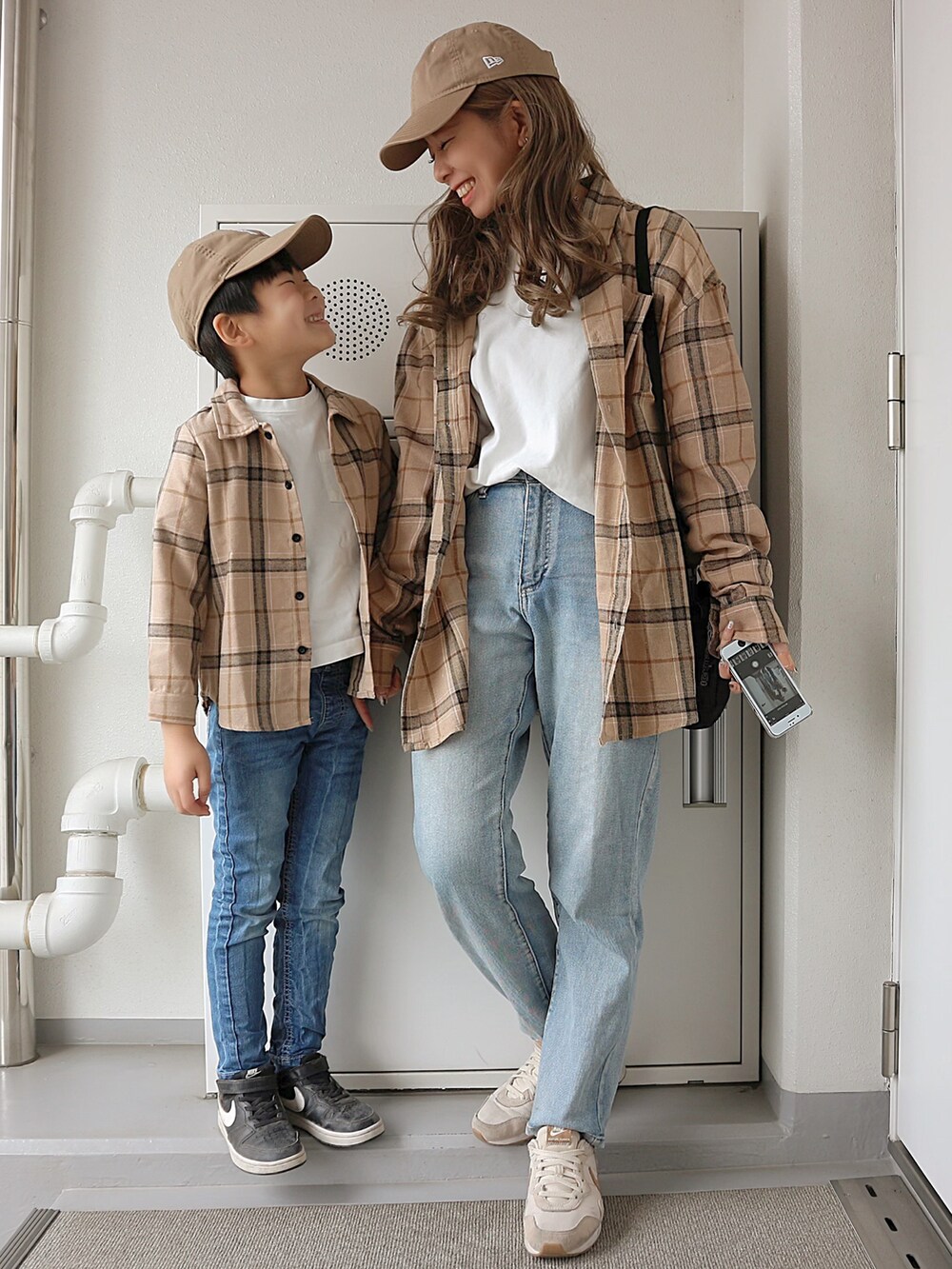 ブラック系のショルダーバッグ、ベージュ系のスニーカー、ベージュ系のキャップを着用したレディースの春コーディネートの2枚目の写真