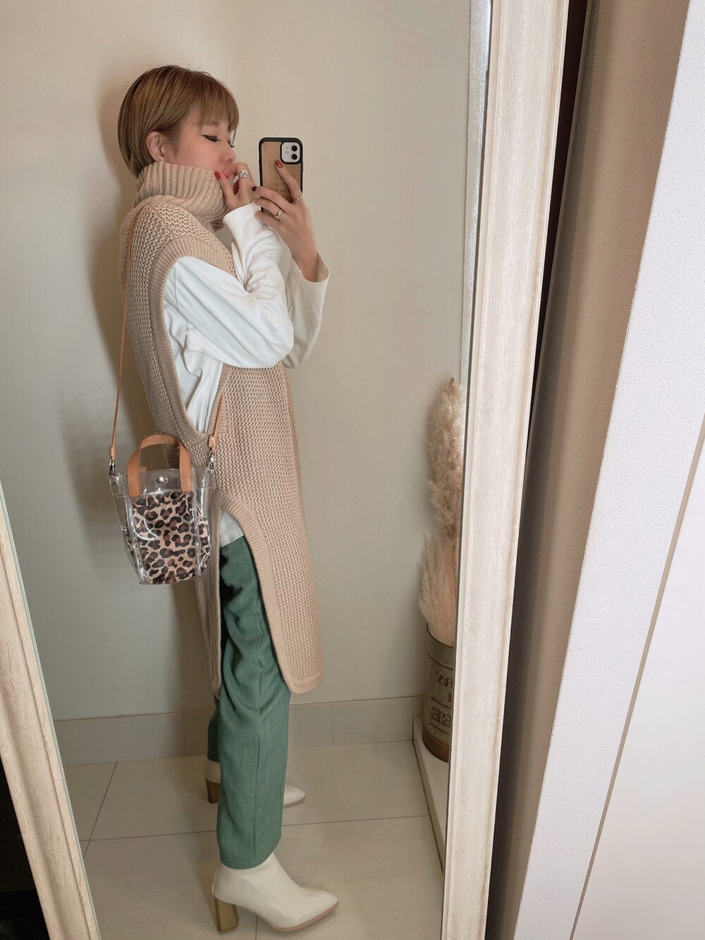 ベージュ系のベスト、ベージュ系のショルダーバッグを着用したレディースの冬コーディネートの2枚目の写真