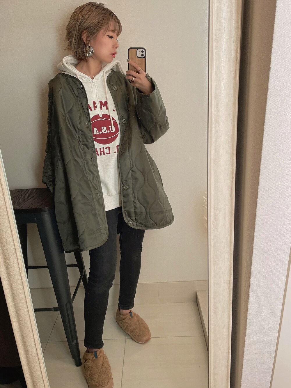 グリーン系のモッズコート、ホワイト系のショルダーバッグ、ベージュ系のスリッポンを着用したレディースの秋コーディネートの4枚目の写真